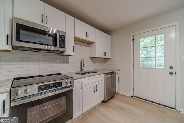3404 Broxton Mill Way, Snellville, GA 30039 - kitchen with appliances with stainless steel finishes, light wood-type flooring, light stone counters, white cabinetry, and backsplash