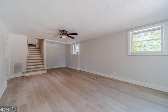 3404 Broxton Mill Way, Snellville, GA 30039 - spare room featuring a textured ceiling, light wood-style flooring, stairs, and a ceiling fan