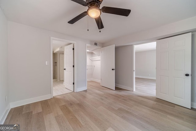 3404 Broxton Mill Way, Snellville, GA 30039 - unfurnished bedroom with a walk in closet, light wood-type flooring, ceiling fan, and a closet