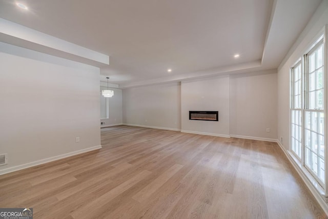 3404 Broxton Mill Way, Snellville, GA 30039 - unfurnished living room with plenty of natural light, light wood finished floors, a glass covered fireplace, and recessed lighting