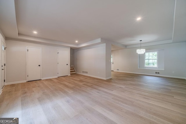 3404 Broxton Mill Way, Snellville, GA 30039 - unfurnished living room with a tray ceiling, stairs, light wood finished floors, and recessed lighting