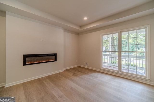 3404 Broxton Mill Way, Snellville, GA 30039 - unfurnished living room featuring a glass covered fireplace, wood finished floors, plenty of natural light, and recessed lighting