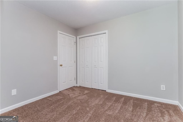 112 Hawkeye Ln, Conyers, GA 30012 - unfurnished bedroom featuring carpet, baseboards, and a closet