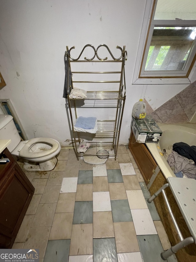 938 Mandeville Rd, Carrollton, GA 30117 - bathroom with a tub to relax in, toilet, and tile patterned floors