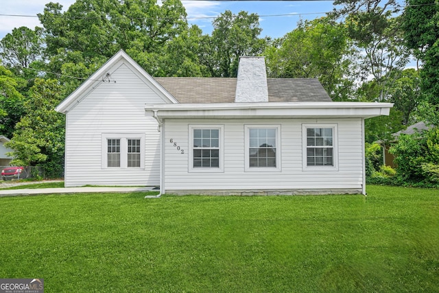 6802 Ida St, Lithonia, GA 30058 - rear view of property featuring a lawn, roof with shingles, and a chimney