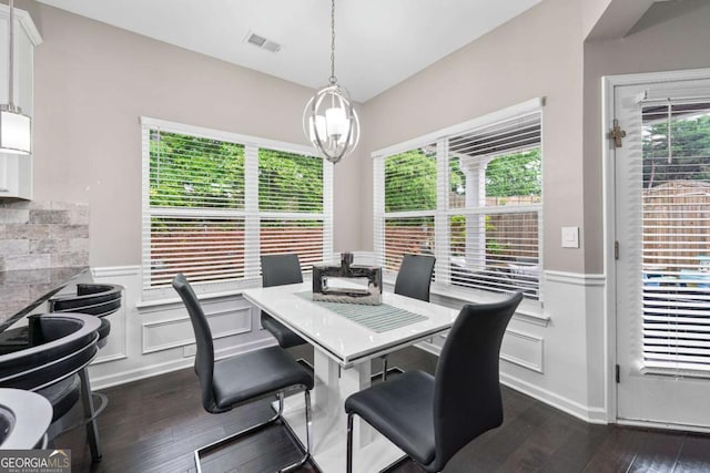 2939 Woodward Down Trl, Buford, GA 30519 - dining area featuring a wainscoted wall, dark wood-style floors, a chandelier, and a decorative wall