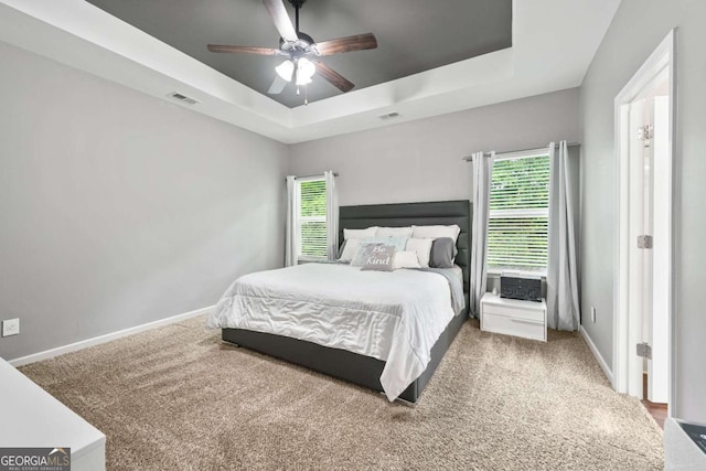 2939 Woodward Down Trl, Buford, GA 30519 - carpeted bedroom with multiple windows, a tray ceiling, baseboards, and a ceiling fan