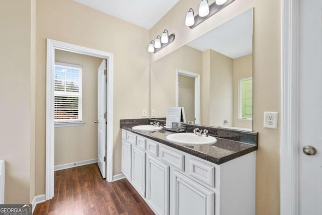 2939 Woodward Down Trl, Buford, GA 30519 - bathroom with double vanity, wood finished floors, and baseboards
