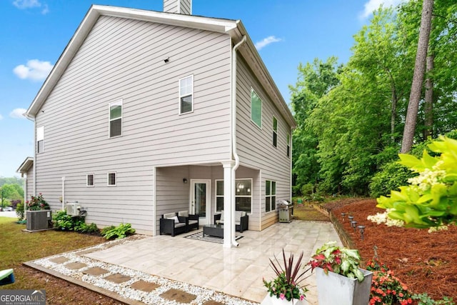 2939 Woodward Down Trl, Buford, GA 30519 - rear view of house featuring a chimney, an outdoor living space, a patio area, and central AC unit