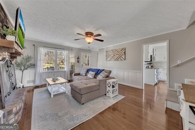 3271 Sutcliffe Rdg, Marietta, GA 30064 - living room featuring a textured ceiling, wood finished floors, a ceiling fan, and wainscoting
