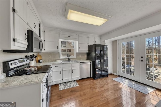 3271 Sutcliffe Rdg, Marietta, GA 30064 - kitchen with appliances with stainless steel finishes, a sink, white cabinets, hardwood / wood-style floors, and a textured ceiling
