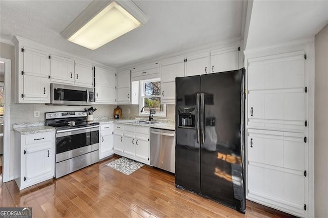 3271 Sutcliffe Rdg, Marietta, GA 30064 - kitchen featuring stainless steel appliances, white cabinets, a sink, hardwood / wood-style flooring, and backsplash