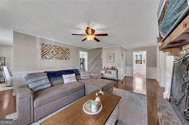 3271 Sutcliffe Rdg, Marietta, GA 30064 - living area featuring a textured ceiling, a ceiling fan, crown molding, hardwood / wood-style floors, and wainscoting