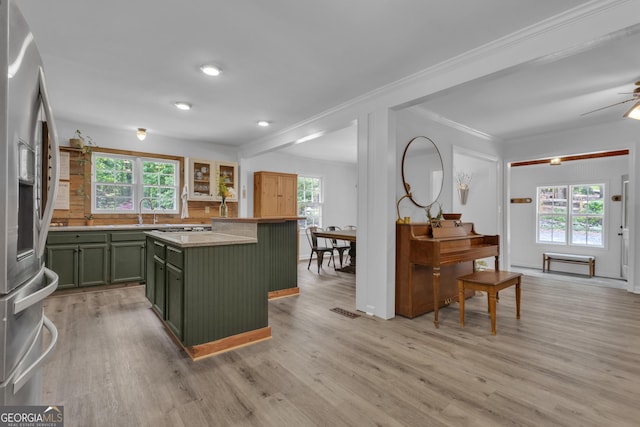 6290 Cascade Palmetto Hwy, Fairburn, GA 30213 - kitchen with green cabinets, stainless steel fridge with ice dispenser, crown molding, light wood-type flooring, and light countertops