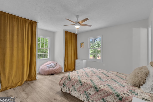 6290 Cascade Palmetto Hwy, Fairburn, GA 30213 - bedroom with light wood-style flooring, a textured ceiling, and a ceiling fan