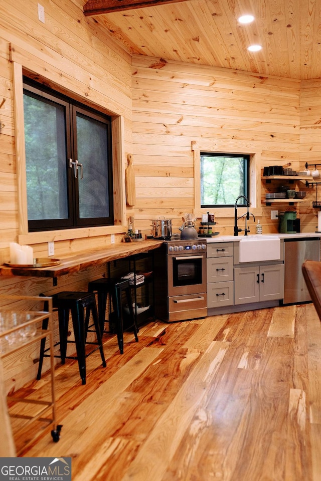 6290 Cascade Palmetto Hwy, Fairburn, GA 30213 - kitchen with appliances with stainless steel finishes, wood ceiling, wood walls, a sink, and light wood finished floors