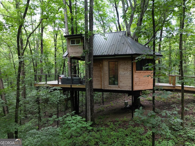6290 Cascade Palmetto Hwy, Fairburn, GA 30213 - view of property exterior with metal roof, a view of trees, and a wooden deck
