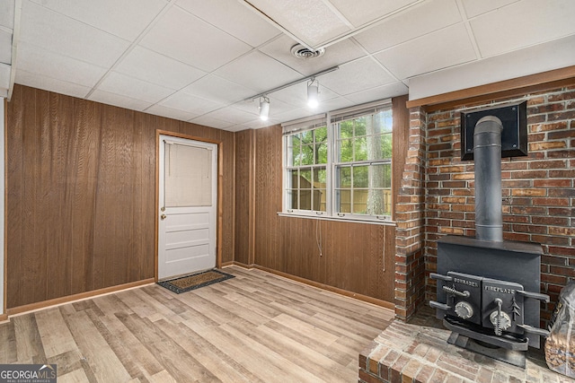 3431 Alcan Way, Tucker, GA 30084 - foyer with a wood stove, wood walls, light wood-type flooring, rail lighting, and baseboards
