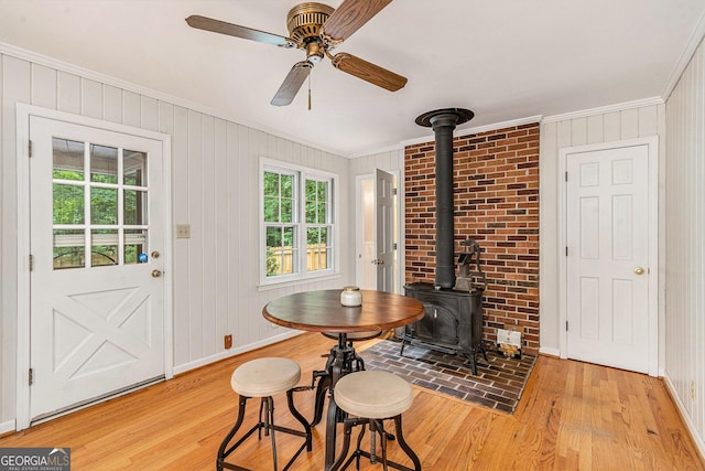3431 Alcan Way, Tucker, GA 30084 - dining space with ornamental molding, light wood finished floors, a wood stove, ceiling fan, and baseboards
