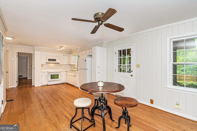 3431 Alcan Way, Tucker, GA 30084 - dining room featuring ornamental molding, light wood finished floors, a ceiling fan, baseboards, and wood walls