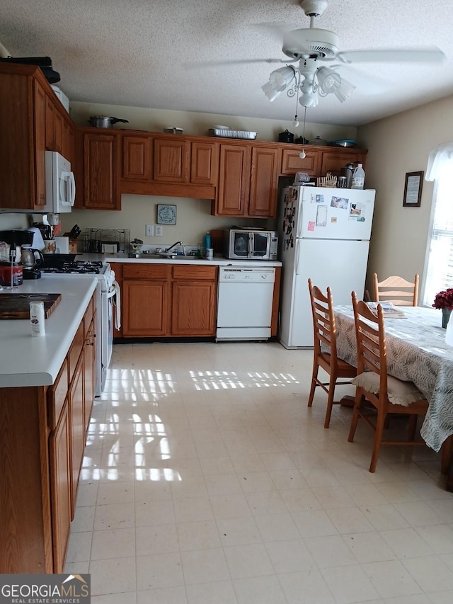 920 Courthouse Rd, Temple, GA 30179 - kitchen featuring white appliances, a sink, light countertops, ceiling fan, and brown cabinets