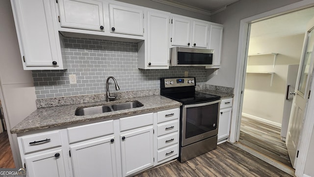 4326 Ga Highway 109, Molena, GA 30258 - kitchen with appliances with stainless steel finishes, a sink, dark wood finished floors, decorative backsplash, and white cabinets
