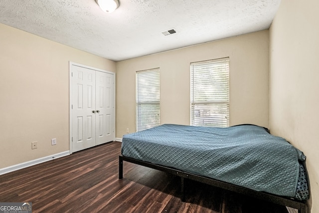 105 N River Dr Unit A, Atlanta, GA 30350 - bedroom with dark wood-type flooring, a textured ceiling, and a closet