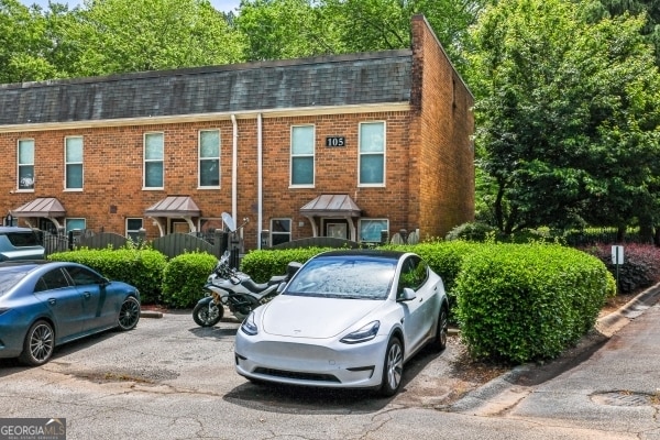 105 N River Dr Unit A, Atlanta, GA 30350 - view of front of property featuring uncovered parking, brick siding, and roof with shingles