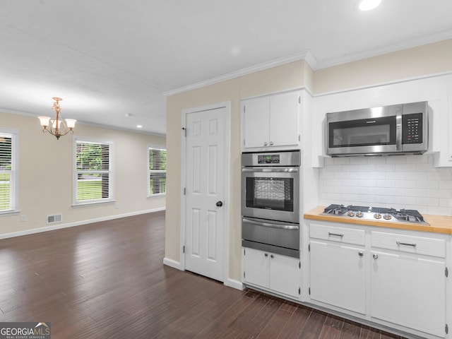 117 Thomas St, Griffin, GA 30224 - kitchen featuring stainless steel appliances, a warming drawer, ornamental molding, decorative backsplash, and a chandelier