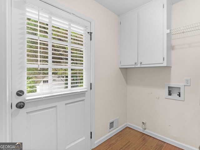 117 Thomas St, Griffin, GA 30224 - laundry room featuring cabinet space, wood finished floors, plenty of natural light, and baseboards