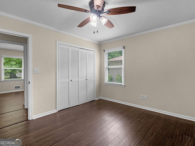 117 Thomas St, Griffin, GA 30224 - unfurnished bedroom with dark wood-style floors, baseboards, a closet, multiple windows, and crown molding