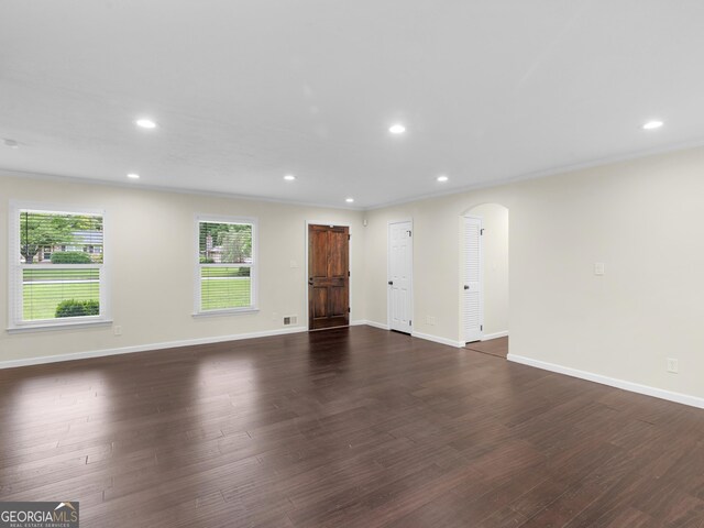 117 Thomas St, Griffin, GA 30224 - unfurnished living room with arched walkways, dark wood-style floors, baseboards, and recessed lighting
