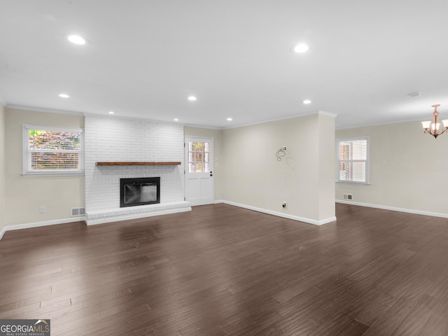117 Thomas St, Griffin, GA 30224 - unfurnished living room with ornamental molding, baseboards, a brick fireplace, recessed lighting, and dark wood-type flooring