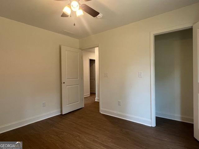 189 Warner Rd, Barnesville, GA 30204 - unfurnished bedroom featuring baseboards, dark wood-style floors, and a ceiling fan