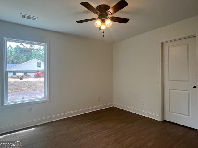 189 Warner Rd, Barnesville, GA 30204 - empty room with dark wood finished floors, ceiling fan, and baseboards
