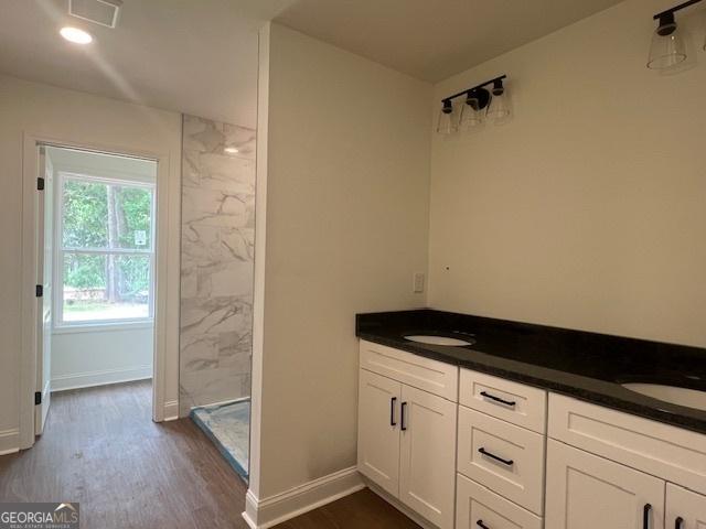 189 Warner Rd, Barnesville, GA 30204 - full bath with a stall shower, double vanity, wood finished floors, and baseboards