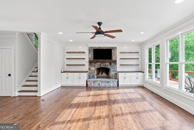 590 Arthur Rd, Canton, GA 30115 - unfurnished living room with stairs, wood finished floors, a ceiling fan, ornamental molding, and a stone fireplace