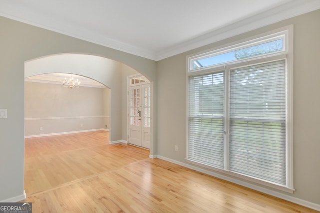 165 Hidden Lake Dr, Fayetteville, GA 30215 - spare room featuring arched walkways, ornamental molding, a chandelier, wood finished floors, and baseboards