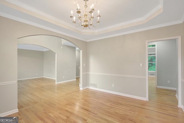165 Hidden Lake Dr, Fayetteville, GA 30215 - empty room featuring arched walkways, light wood finished floors, a chandelier, a tray ceiling, and crown molding