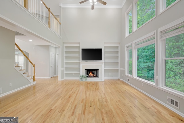 165 Hidden Lake Dr, Fayetteville, GA 30215 - unfurnished living room featuring a ceiling fan, baseboards, a high ceiling, wood finished floors, and a fireplace with flush hearth