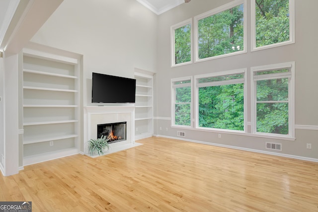 165 Hidden Lake Dr, Fayetteville, GA 30215 - unfurnished living room with baseboards, a high ceiling, built in shelves, wood finished floors, and a high end fireplace