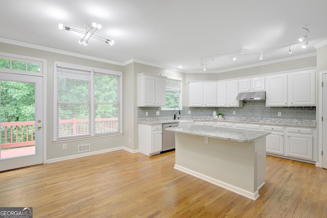 165 Hidden Lake Dr, Fayetteville, GA 30215 - kitchen with stainless steel dishwasher, under cabinet range hood, white cabinets, ornamental molding, and decorative backsplash