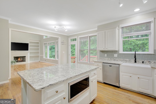 165 Hidden Lake Dr, Fayetteville, GA 30215 - kitchen featuring stainless steel dishwasher, built in microwave, a sink, crown molding, and light wood-style flooring
