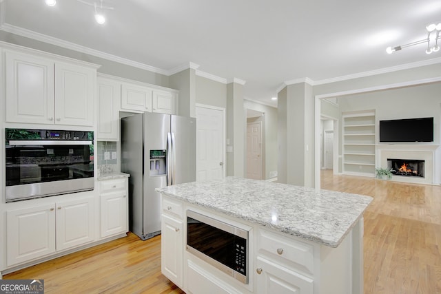 165 Hidden Lake Dr, Fayetteville, GA 30215 - kitchen with stainless steel appliances, ornamental molding, light wood-type flooring, white cabinetry, and open floor plan