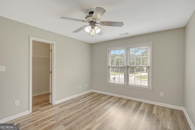 165 Hidden Lake Dr, Fayetteville, GA 30215 - unfurnished bedroom featuring light wood finished floors, a spacious closet, baseboards, a closet, and a ceiling fan