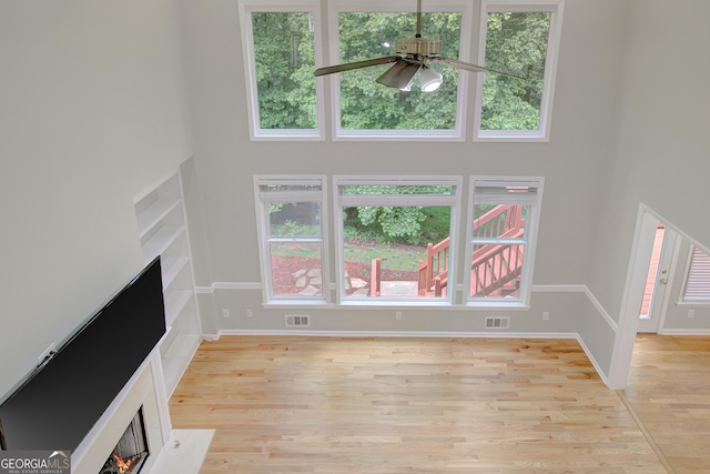165 Hidden Lake Dr, Fayetteville, GA 30215 - unfurnished living room featuring a fireplace with flush hearth, a high ceiling, ceiling fan, light wood finished floors, and baseboards