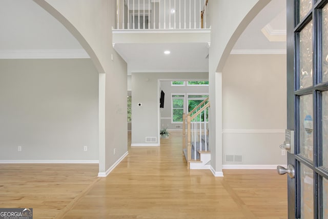 165 Hidden Lake Dr, Fayetteville, GA 30215 - foyer featuring wood finished floors, crown molding, baseboards, arched walkways, and stairs
