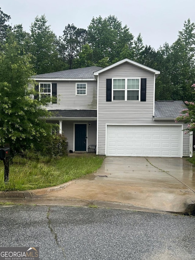 287 Ella Ct, Columbus, GA 31907 - traditional-style house with concrete driveway, a garage, a shingled roof, and view of scattered trees