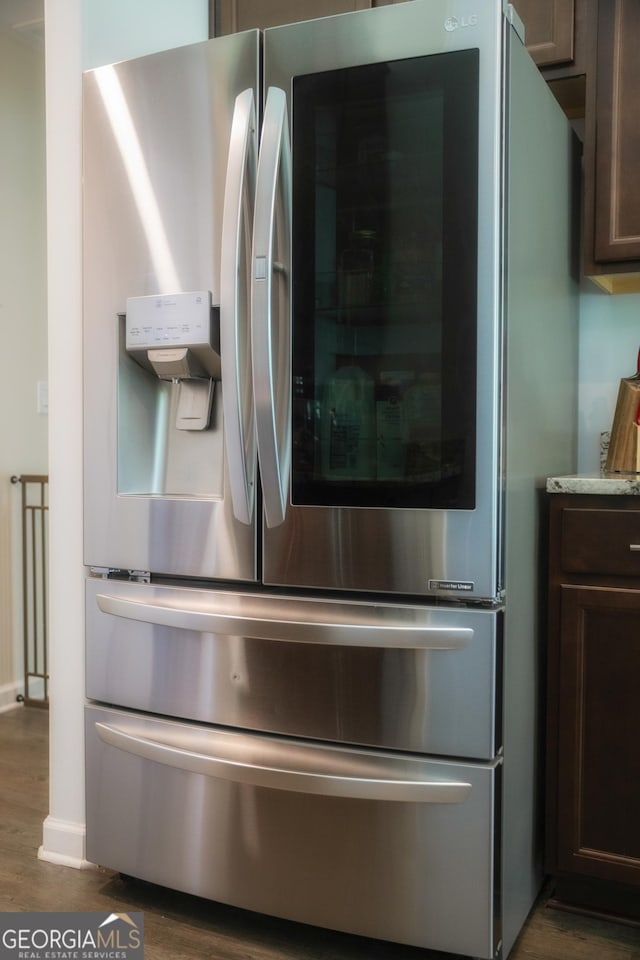 104 Johansen Way, Kingsland, GA 31548 - kitchen view of stainless steel fridge with ice dispenser, dark wood finished floors, and dark brown cabinets