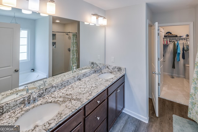 104 Johansen Way, Kingsland, GA 31548 - bathroom featuring wood finished floors, a shower stall, double vanity, a spacious closet, and a garden tub
